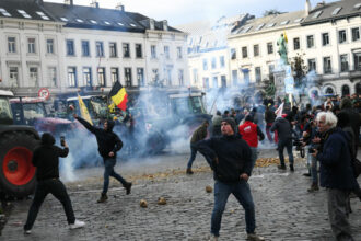 Agricultores atiram batatas perto do Parlamento Europeu durante um protesto - AFP